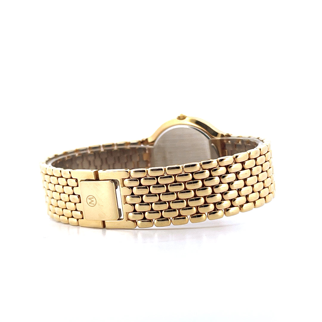 Movado Certo Museum Uhr in Gold mit M-Logo auf der Schliesse von der Seite aufgenommen vor weissem Hintergrund