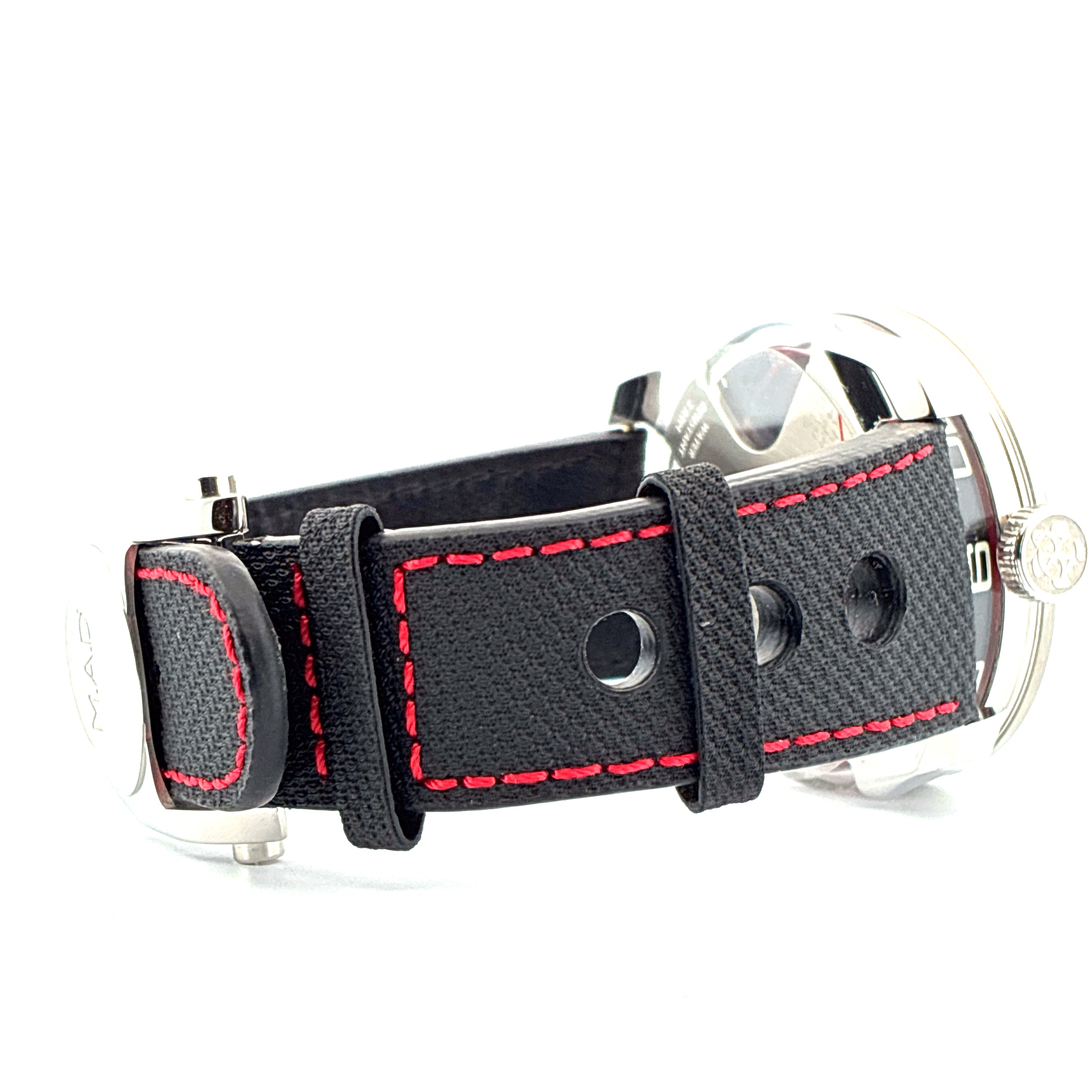 Seitenansicht einer M.A.D. 1 Edition Uhr mit schwarzem Armband und roten Nähten auf weißem Hintergrund