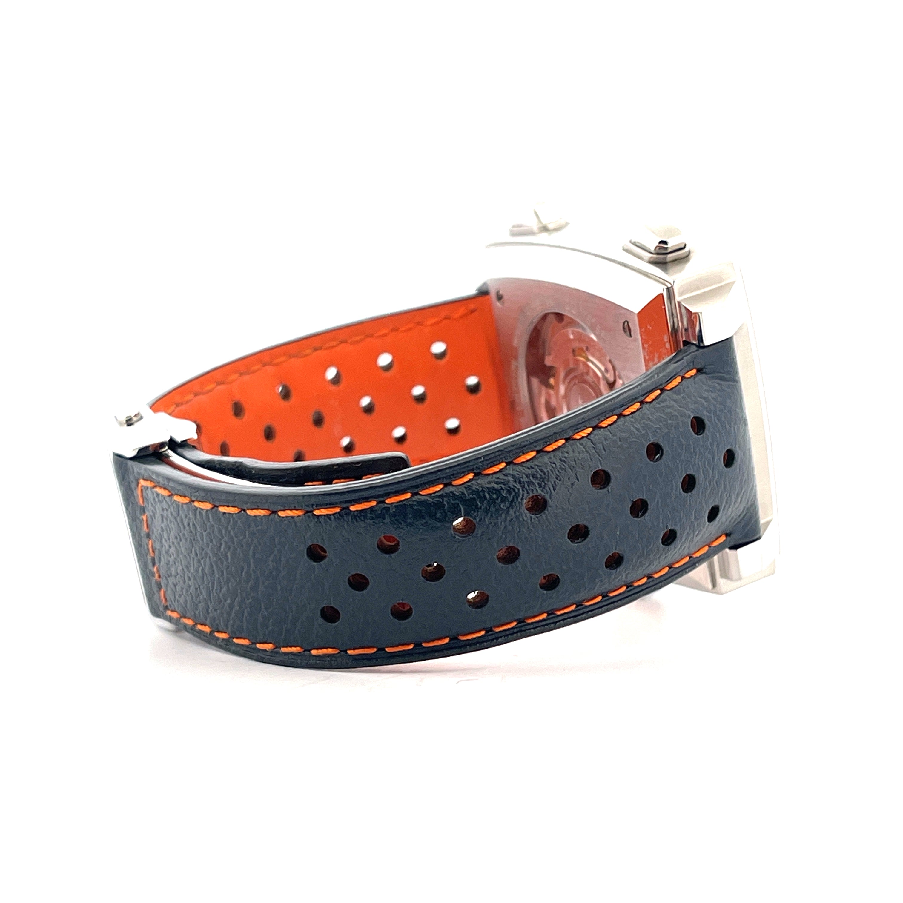 Tag Heuer Monaco Gulf mit dunkelblauem Lederarmband und orangem Futter auf weißem Hintergrund