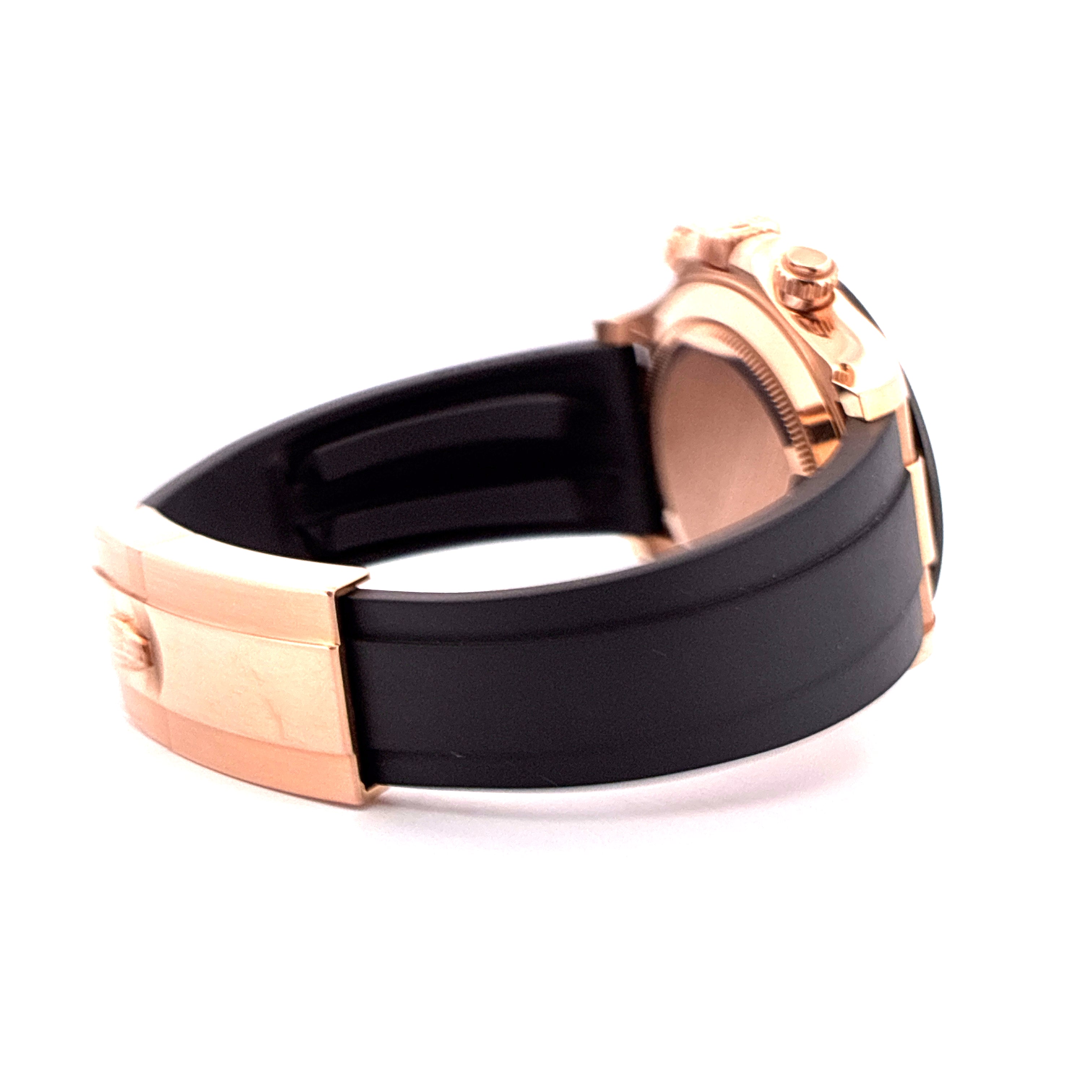 Rolex Daytona mit Roségoldgehäuse, schwarzem Oysterflex-Armband und auffälliger Roségold-Schließe im Seitenprofil auf weiß…