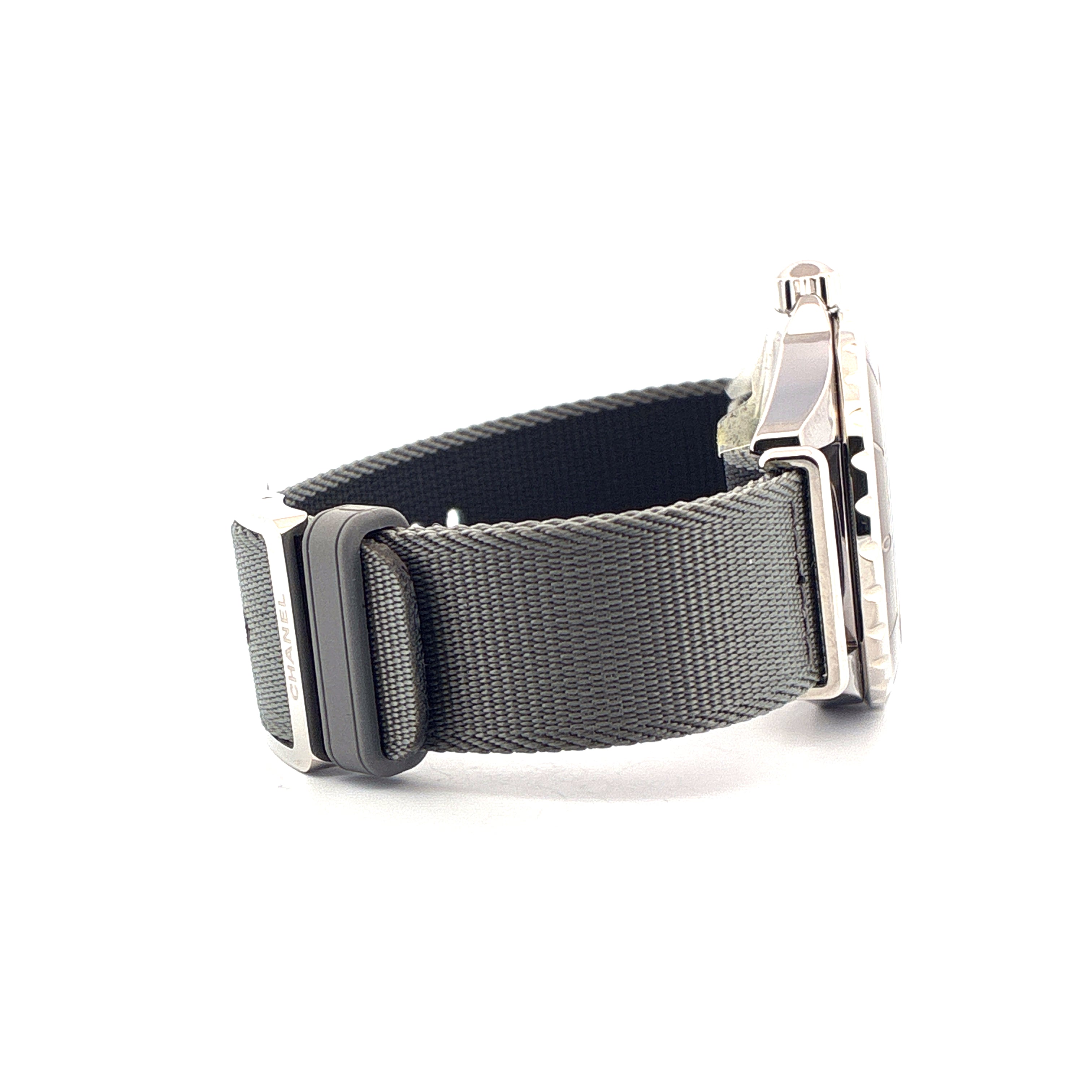 Chanel J12-g10 Uhr mit grauem Stoffarmband und silbernem Gehäuse in Seitenansicht auf weißem Hintergrund