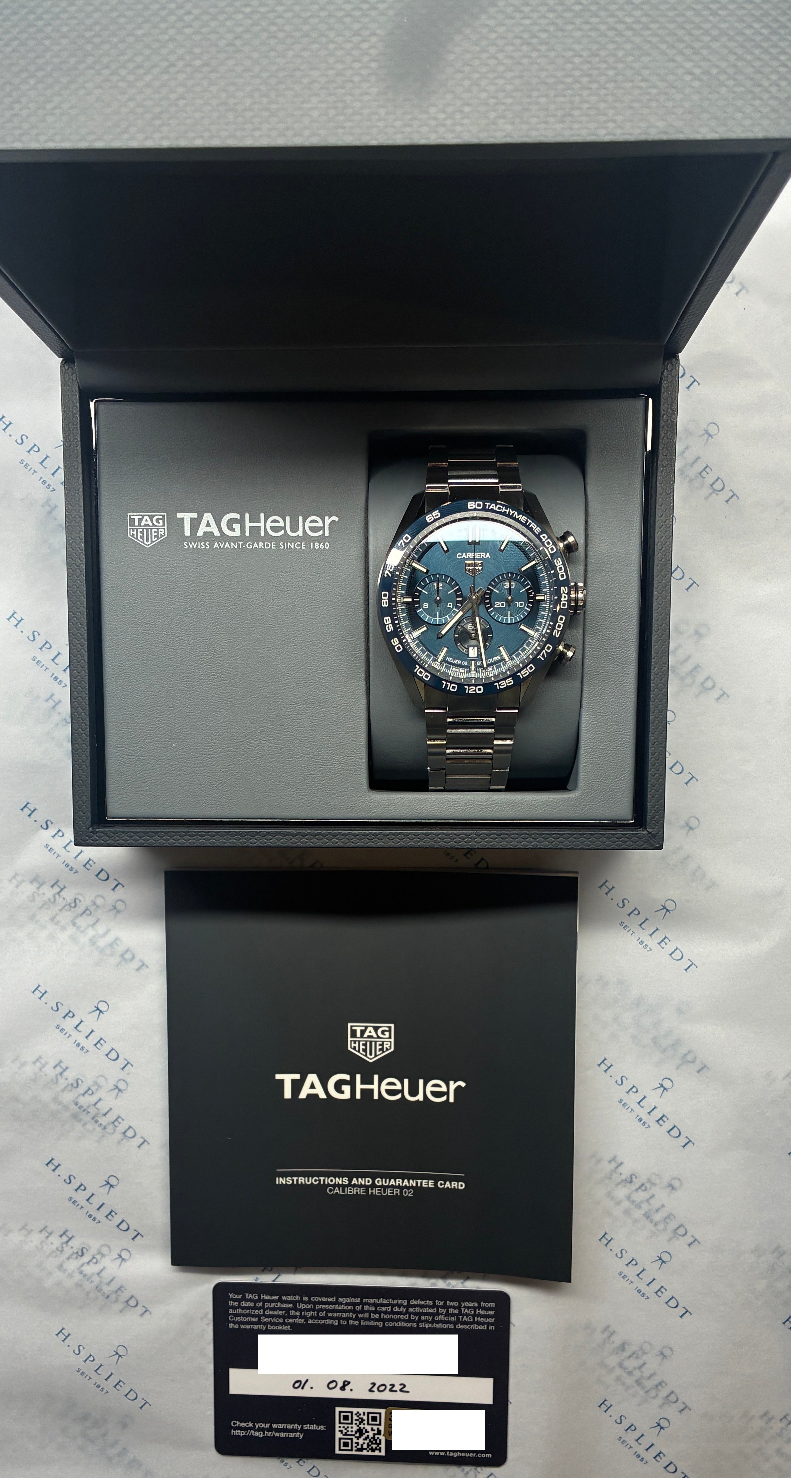 Tag Heuer Carrera Automatik mit blauem Zifferblatt in geöffneter Box mit Papieren