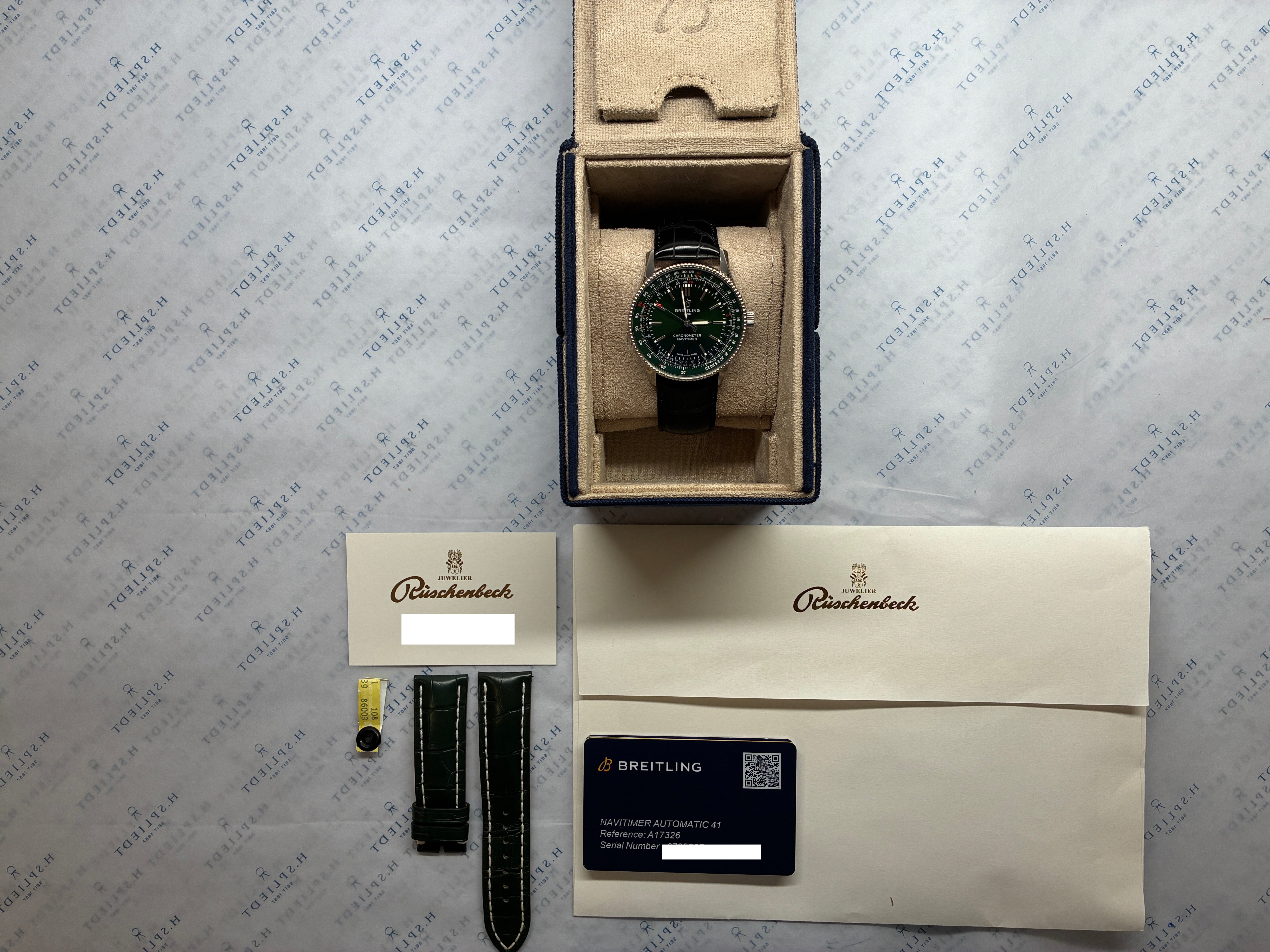 Breitling Navitimer Automatic 41 mit dunkelgrünem Zifferblatt, schwarzem Lederarmband und Zubehör in Nahaufnahme