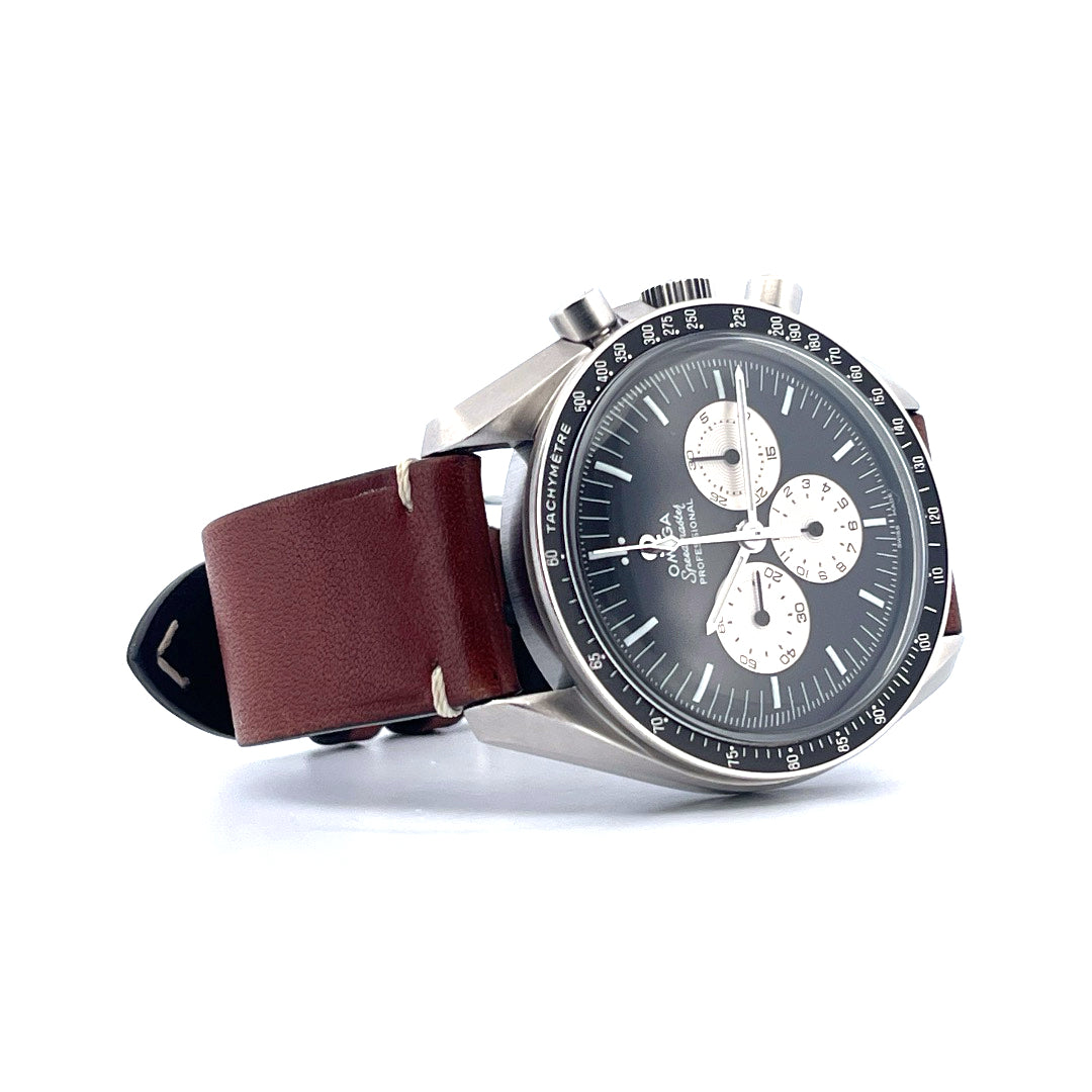 Omega Speedmaster Professional von der Seite mit braunem Lederband und schwarzem Zifferblatt vor weissem Hintergrund