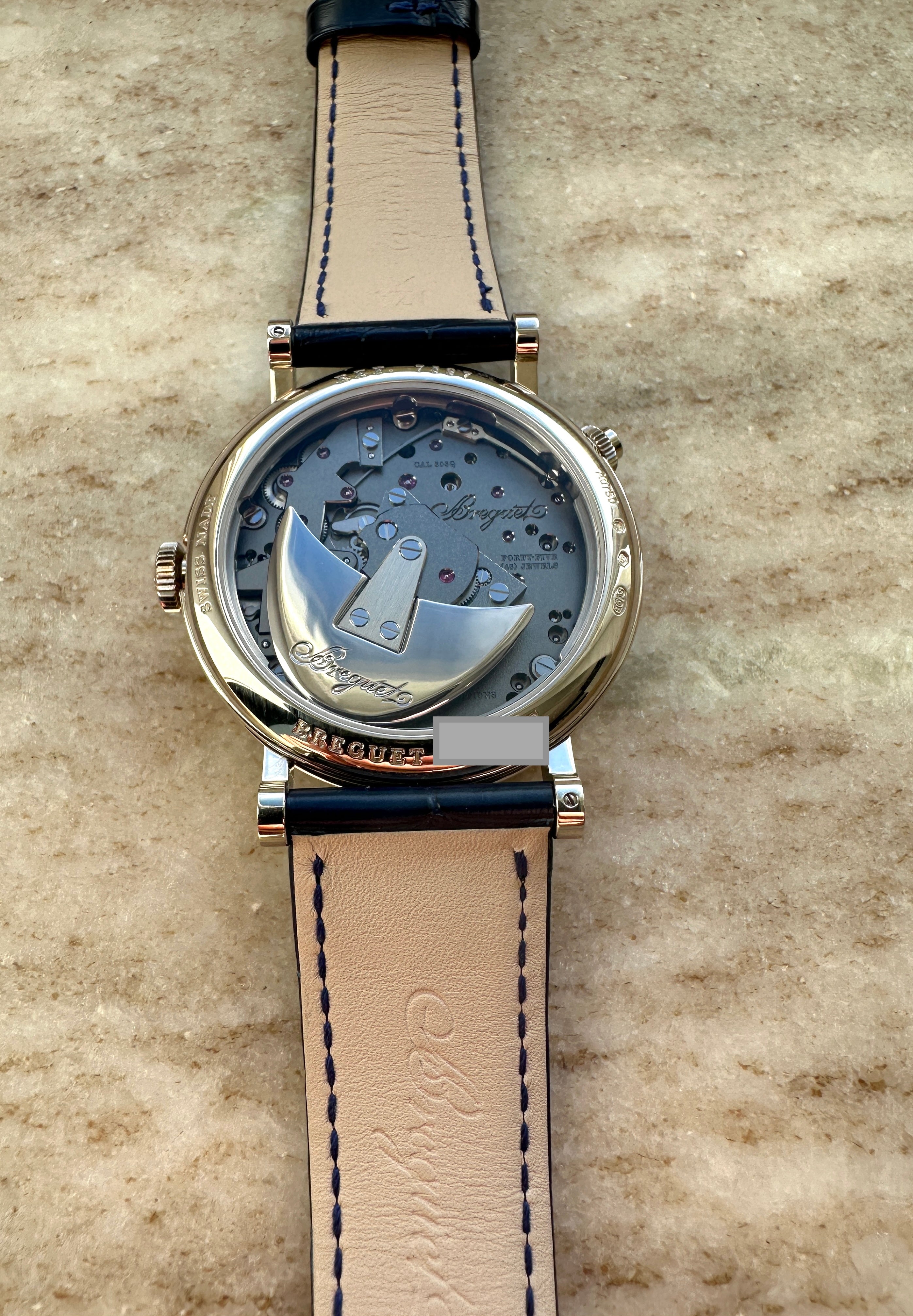 Breguet Tradition Quantieme Retrograde Automatic Weißgold Rückseite mit Sichtboden und Lederarmband auf Stein