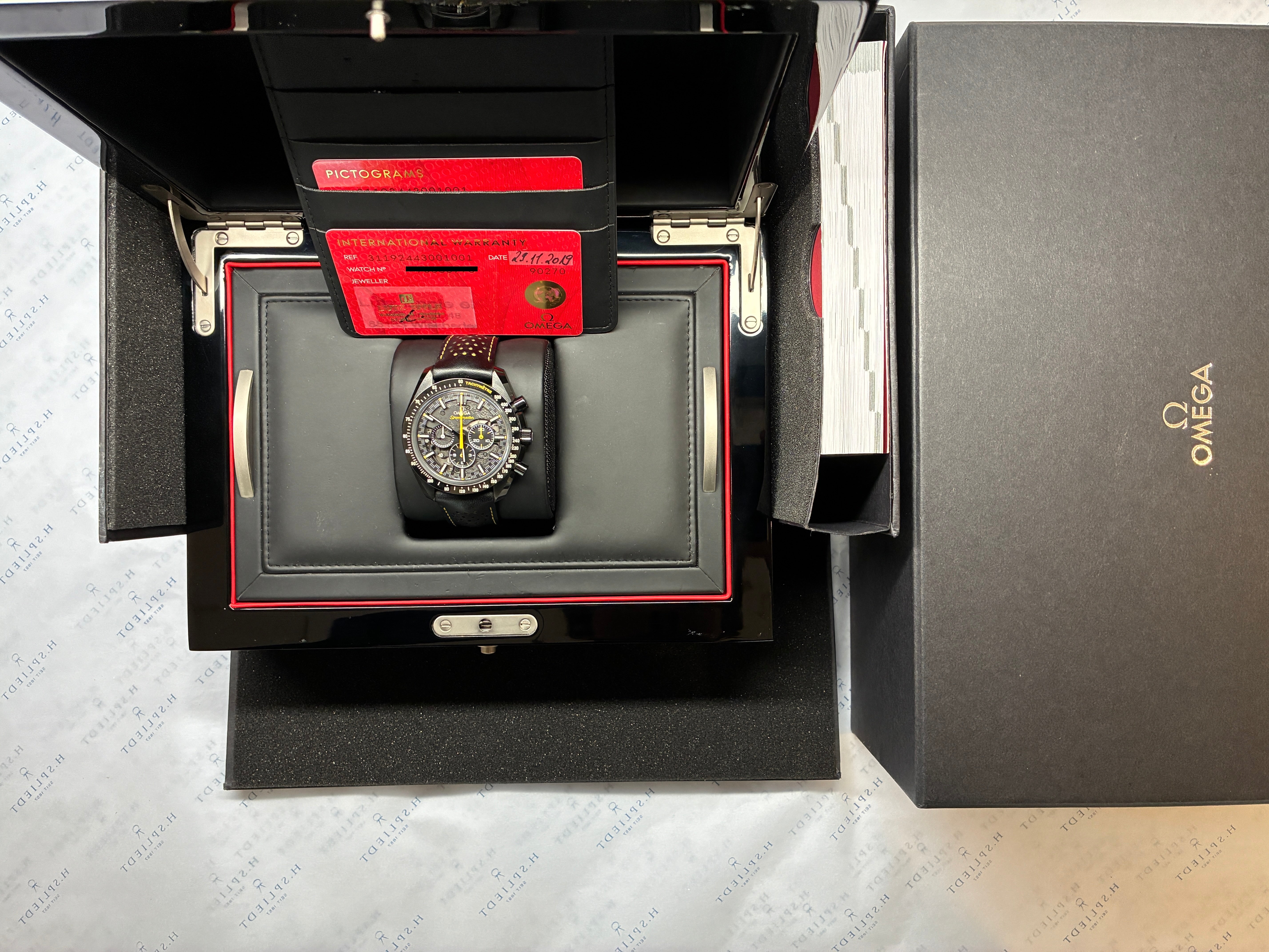 Omega Speedmaster Apollo 8 Dark Side of the Moon in schwarzer Keramik im geöffneten Etui mit Papieren