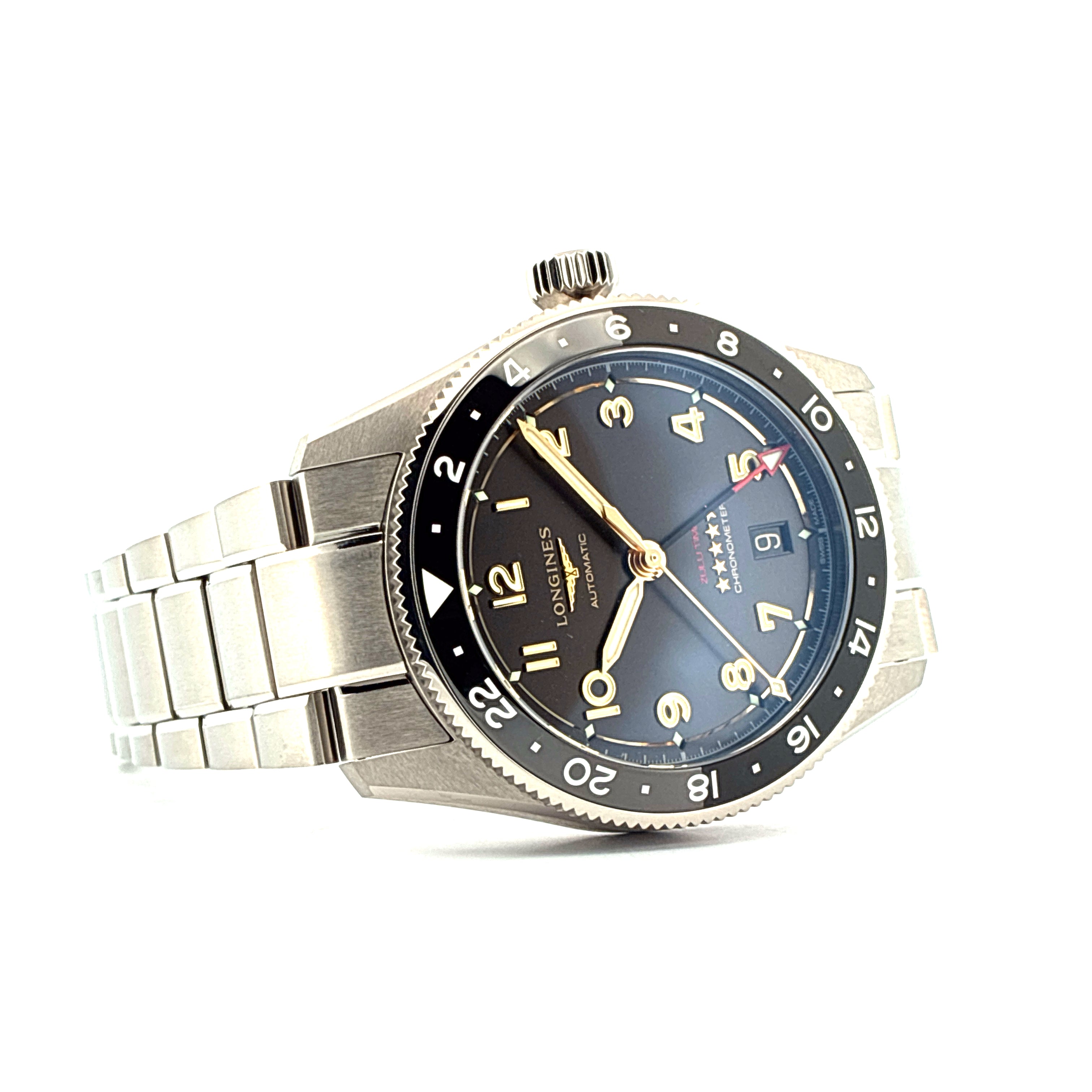 Longines Spirit Zulu Time 39mm mit dunkelgrauem Zifferblatt und goldenen Indizes auf weissem Hintergrund