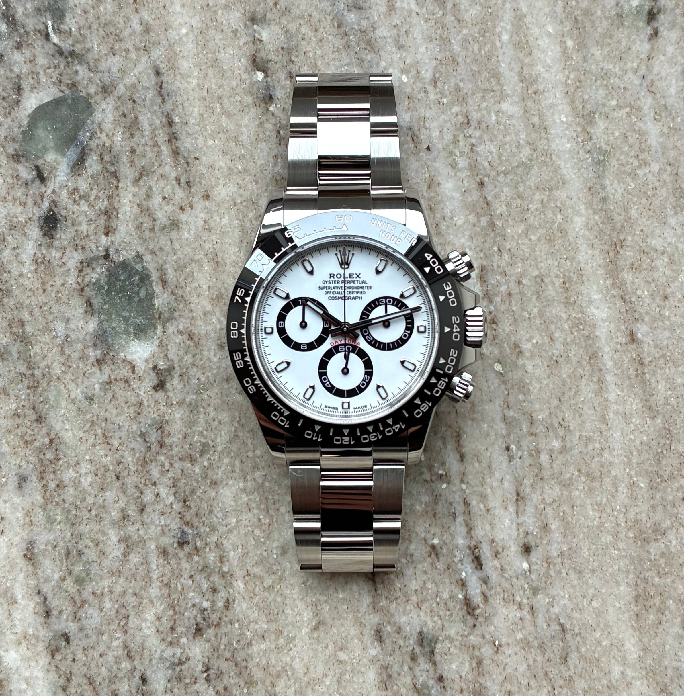 Rolex Daytona Panda-Dial Automatik aus Edelstahl mit weißem Zifferblatt und schmalem Armband auf Marmoruntergrund